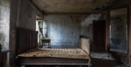 An empty room with an old mattress and bed