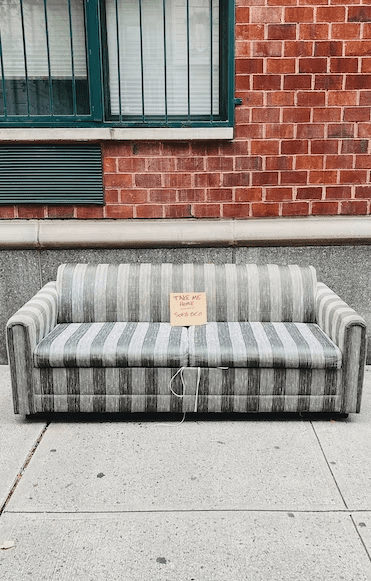 An old couch on a pavement