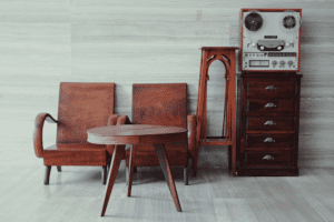 chairs, a table, and an old dresser lined up in front of a wall